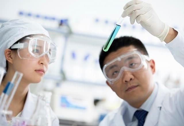 Two researchers looking at vials of liquid